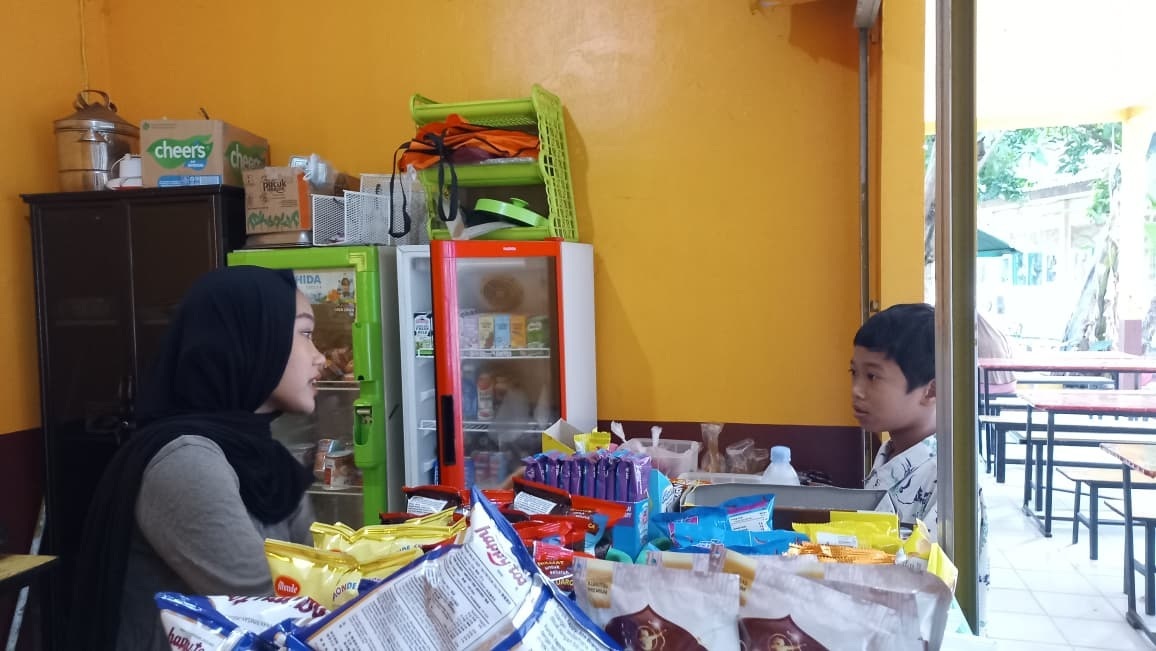 Pedagang di kantin SMPN 6 tengah menata dagangannya sembari menunggu siswa untuk membeli.