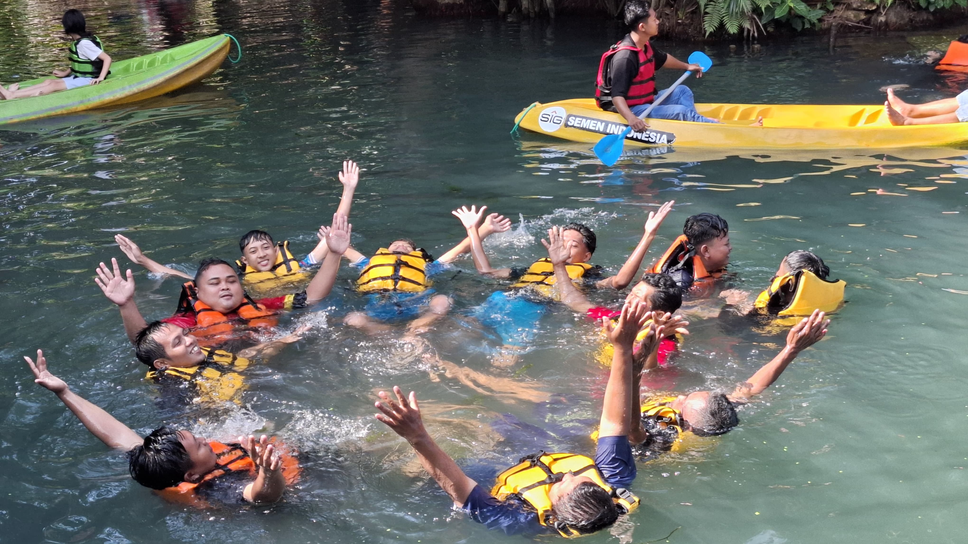 Pengunjung sedang berenang dan mendayung kano menikmati liburan di Wisata Silowo, Desa Mandirejo Merakurak.