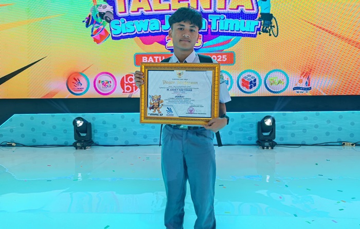 Haeydhar saat membawa piagam Juara 1 LKS Jawa Timur atas bakatnya.