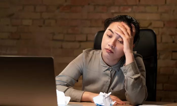 Seorang perempuan yang overthinking saat bekerja.