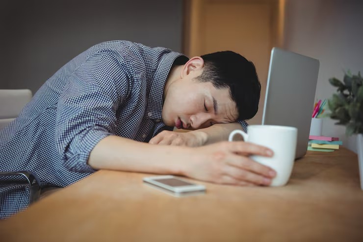 Seorang pekerja tertidur di meja kerja akibat kurang tidur