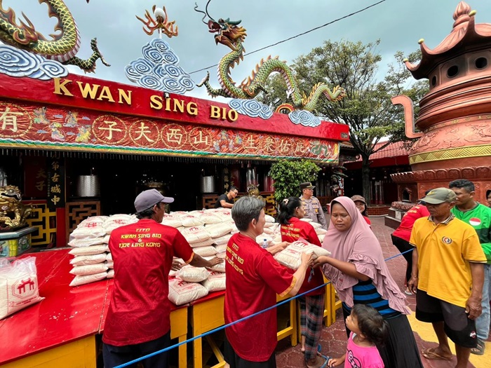 Warga sekitar kelenteng, driver online, asongan, tukang becak, dan  masyarakat kurang mampu antre menerima sembako di halaman TITD Kwan Sing Bio Tuban kemarin (21/10).