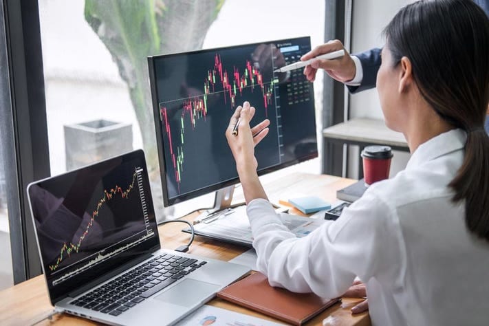 Ilustrasi seorang perempuan sedang melakukan trading di komputer