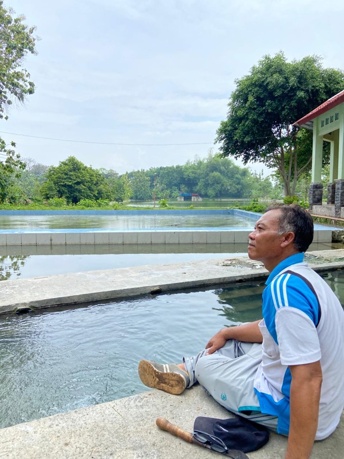 Aksin, kepala Desa Pekuwon, Kecamatan Rengel, Kabupaten Tuban mensyukuri limpahan air Danau Ngerong Pekuwon di atas bukit kapur.