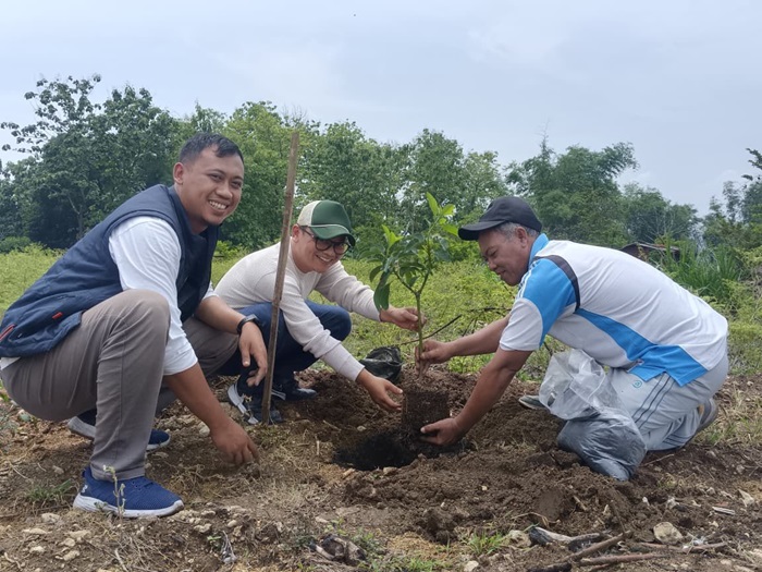 Aksin (kanan) bersama perwakilan EMCL menanam beraneka pohon di atas bukit Pekuwon.