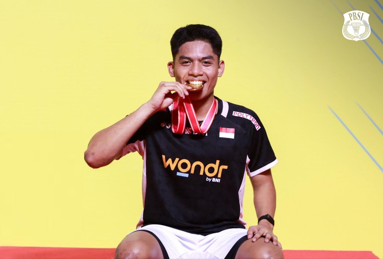 Pebulu tangkis tunggal putra Indonesia Zaki Ubaidillah berpose di podium usai mengalahkan pebulu tangkis China Dong Tian Yao pada final Indonesia Master 2025, Minggu (26/10).