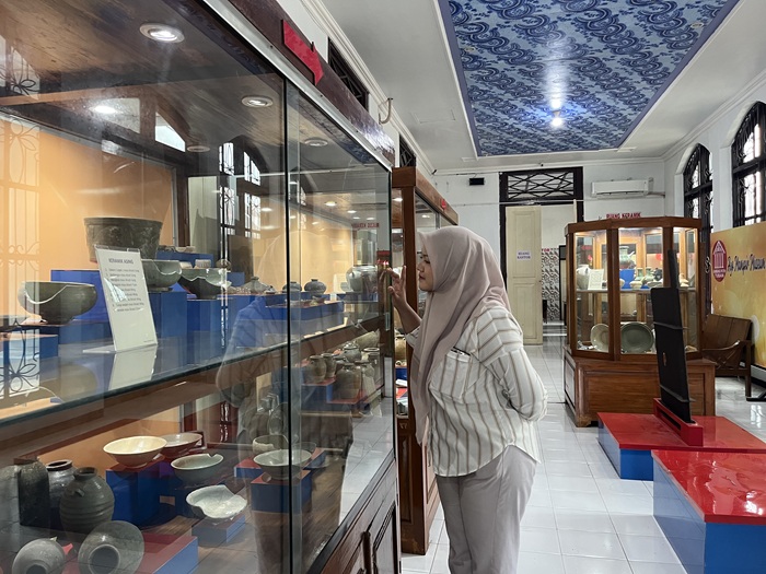 Salah seorang pengunjung Museum Kambang Putih Tuban mengamati dan membaca deskripsi salah satu benda peninggalan sejarah.