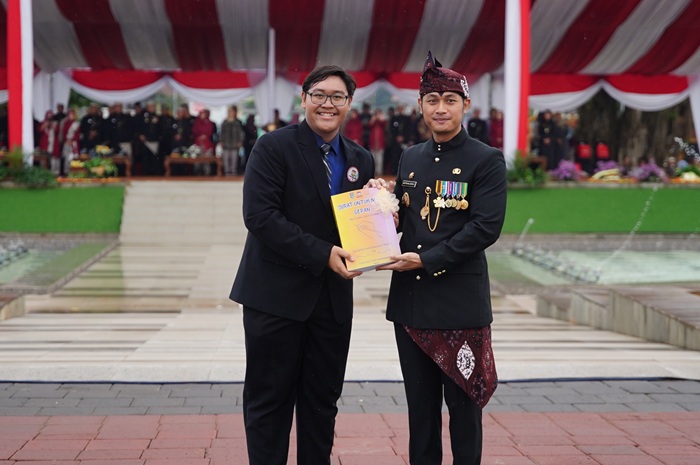 Ketua Forum Anak Kabupaten Tuban Sri Teddy Wiryawan (kiri) menyerahkan buku kompilasi Surat untuk Masa Depan kepada Bupati Tuban Aditya Halindra Faridzky (kanan) di Alun-alun Tuban.