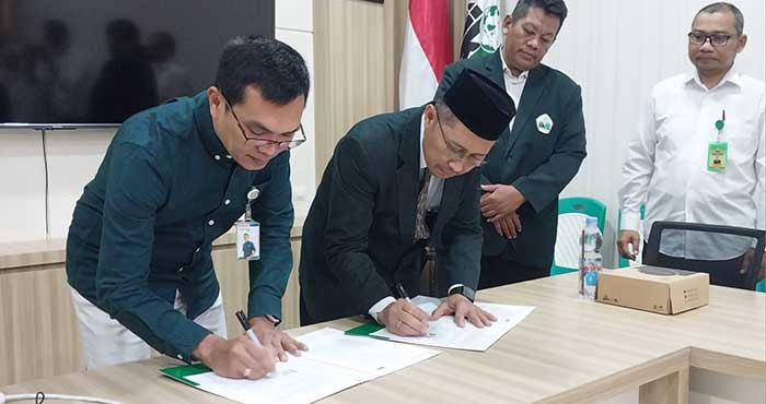 Kepala BPJS Kesehatan Cabang Bojonegoro Wahyu Giyanto bersama Rektor IIKNU Tuban Miftahul Munir menandatangani perjanjian kerja sama pada Rabu (3/12).