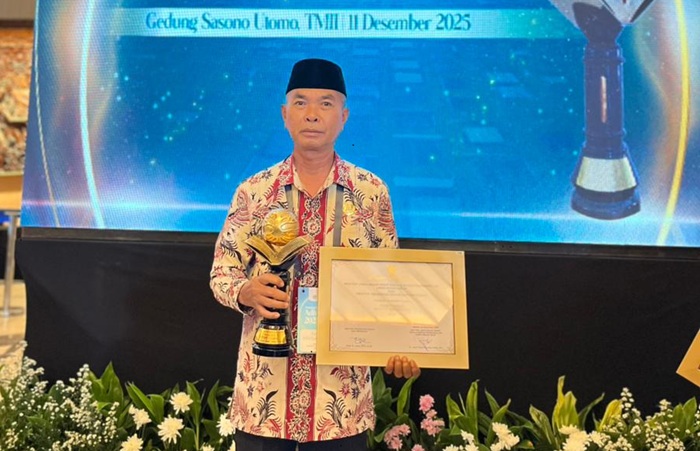 Kepala MTs Negeri 1 Tuban Subiyanto menunjukkan piagam penghargaan Adiwiyata Mandiri 2025.