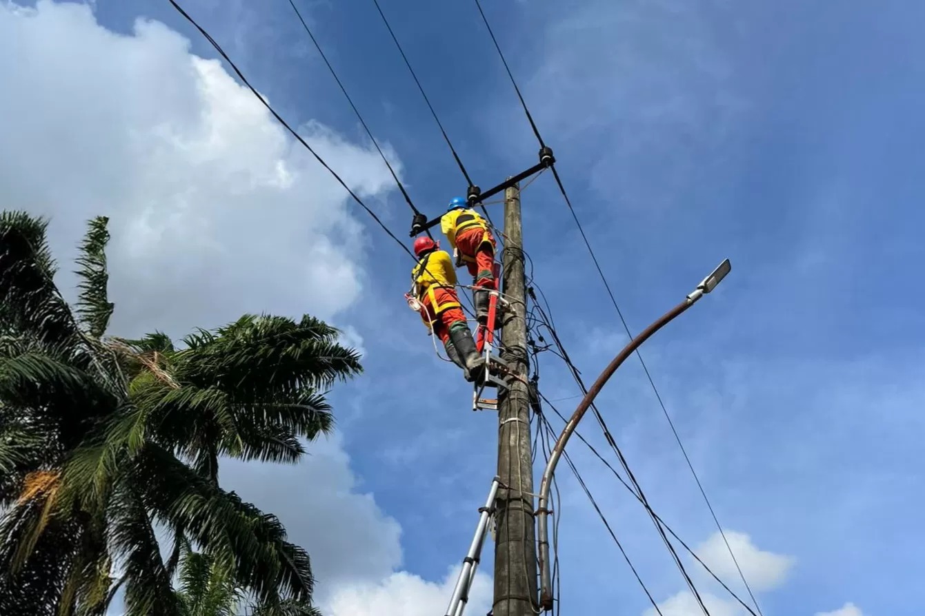 Petugas PLN memperbaiki gardu listrik yang rusak pasca bencana banjir bandang dan longsor di Aceh.