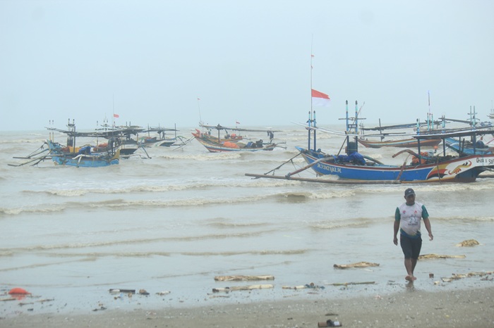 Para nelayan di pesisir Desa Karangsari, Kecamatan Tuban memperbaiki mesin kapalnya di pantai wilayah setempat, kemarin (14/1).
