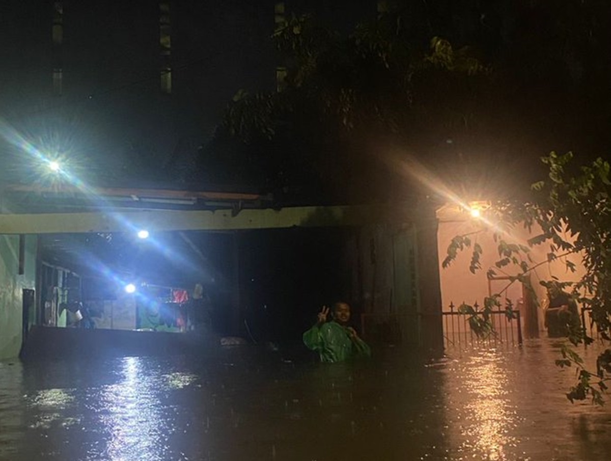 Warga melintas di kawasan permukiman yang terendam banjir akibat tingginya curah hujan di Jakarta