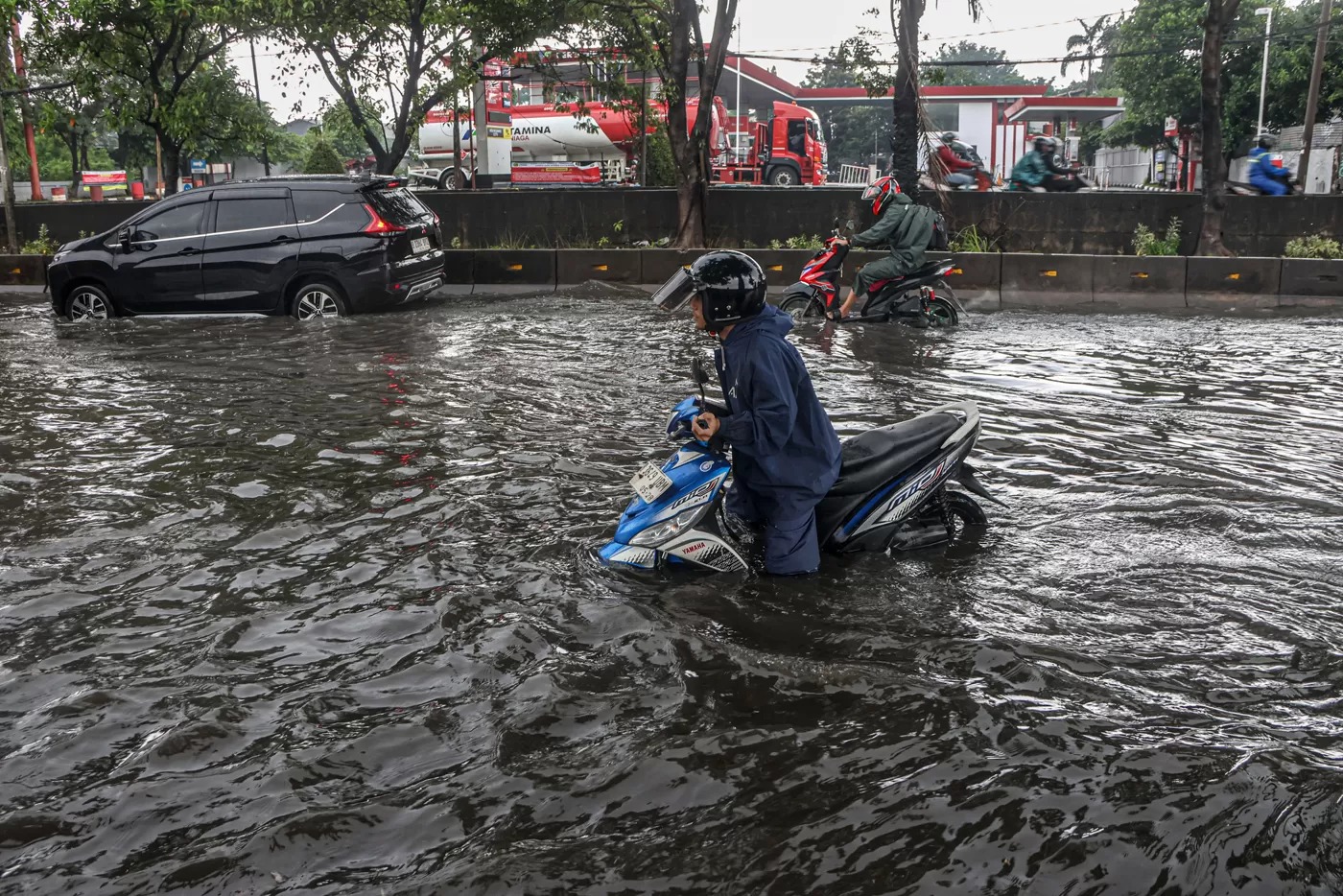 Sejumlah kendaraan menerobos banjir mengenang di jalan Daan Mogo