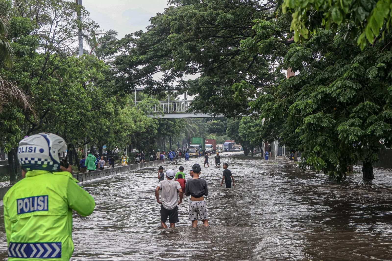 Petugas membantu mendorong kendaraan yang mati setelah menerobos banjir di jalan Daan Mogot, Jakarta, Kamis (22/01).