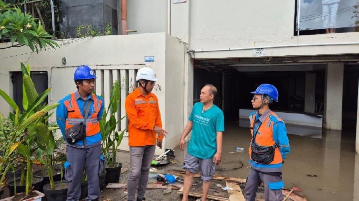 Petugas PLN melakukan koordinasi dan edukasi keamanan listrik dengan salah satu pelanggan terdampak banjir.