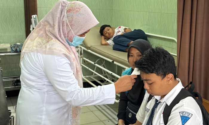 Tenaga kesehatan Puskesmas Montong merawat siswa yang diduga mengalami keracunan.
