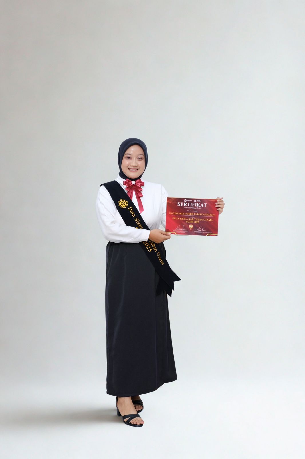 Sachi tampak sumringah menerima selempang dan sertifikat setelah resmi dilantik sebagai Duta Siswa Kabupaten Tuban Utama Putri 2025.