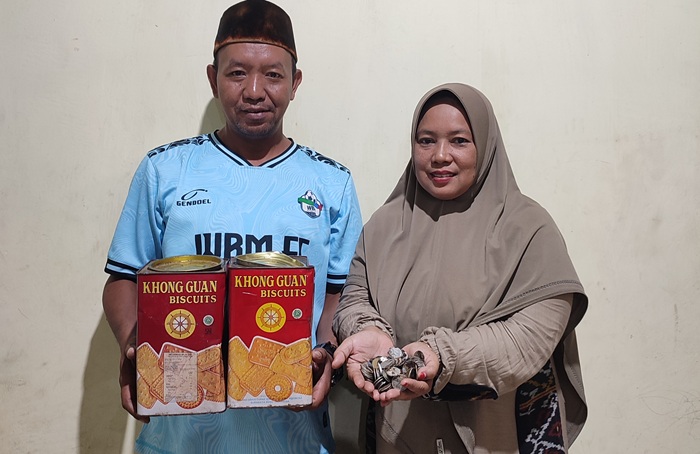 Mohammad Nasrudin bersama istrinya menunjukkan uang koin yang dikumpulkan untuk berangkat menunaikan ibadah haji.