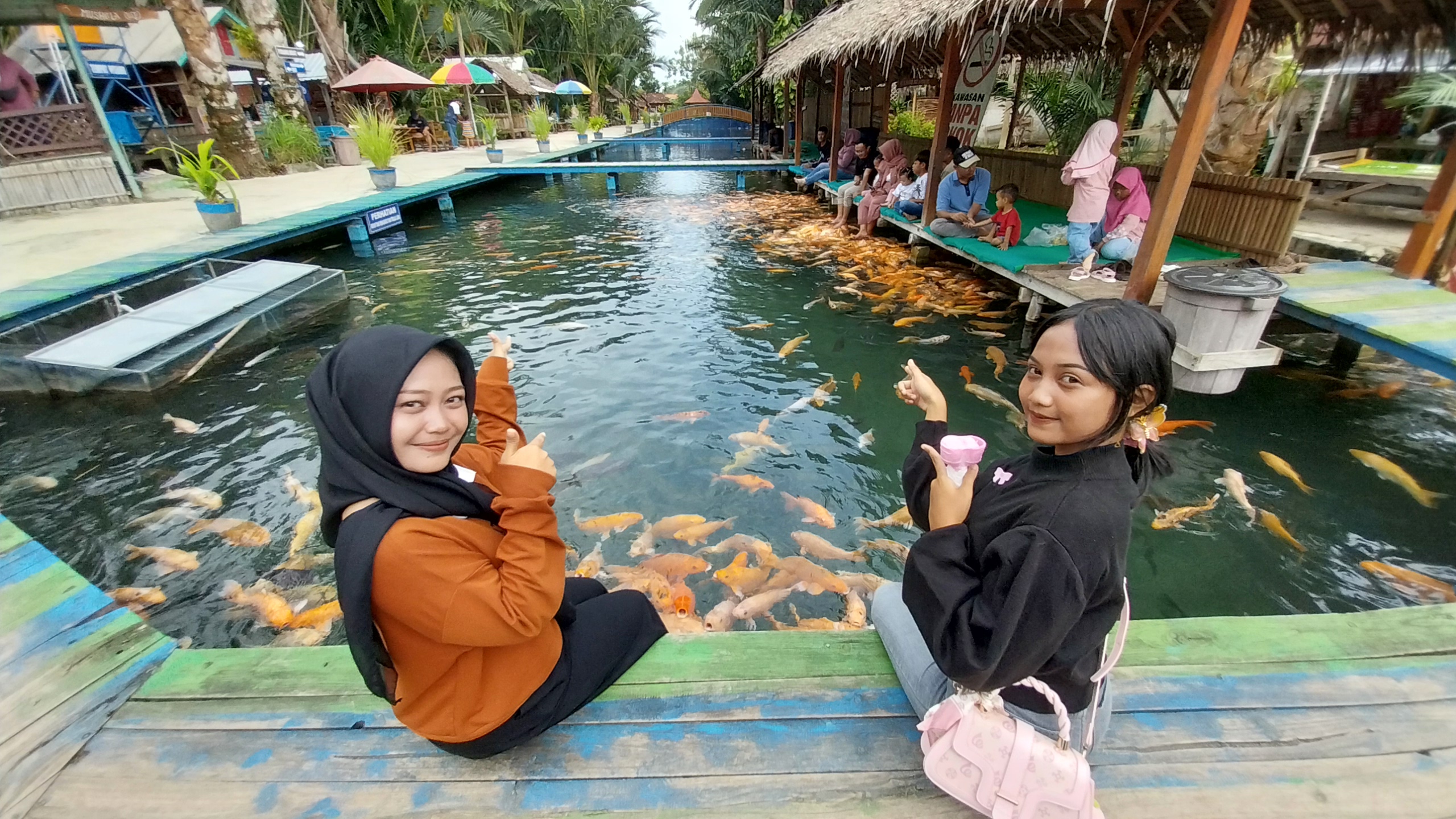 Sejumlah wisatawan di wisata Pelang, Desa Tahulu, Kecamatan Tuban memberi makan ikan sambil menikmati panorama alam sungai dan pohon sagu.