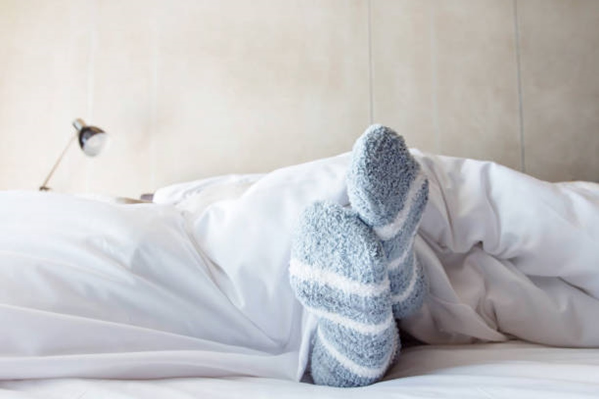 Ilustrasi orang yang tidur dengan menggunakan kaus kaki
