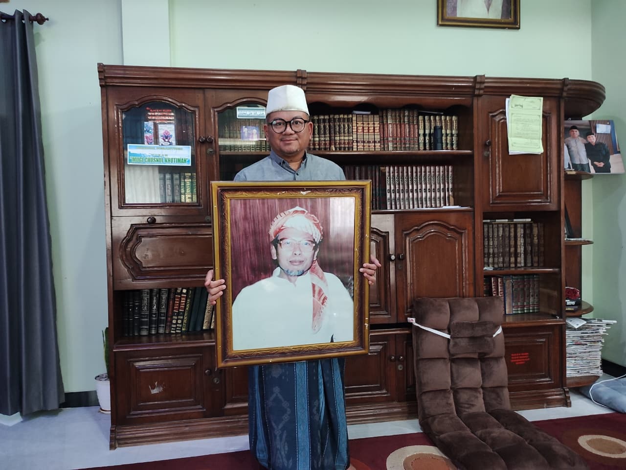 KH Riza Shalihuddin Habibi saat berfoto bersama foto KH Ahmad Syifa Sholih, kemarin (18/2).