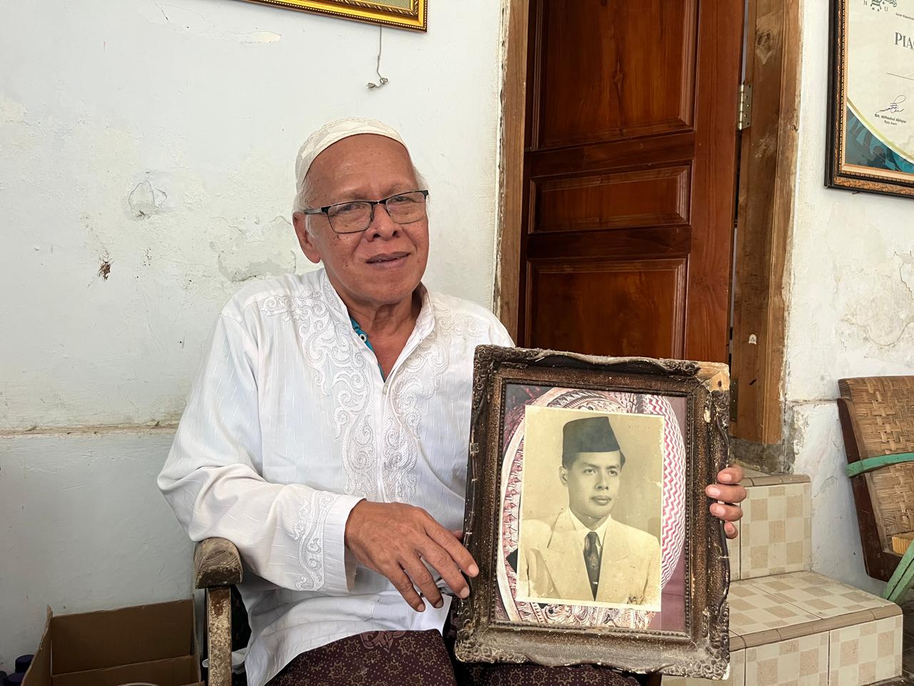 Kyai Ahmad Syakir Ali menggenggam foto sang ayah, KH Ali Manshur, Sabtu (21/2).