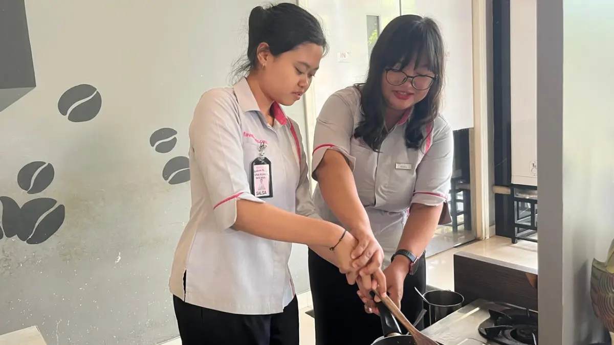 Adelia, HRD Favehotel (kanan) mengajari Salsa anak magang difabel (kiri) di bagian food and baverage untuk membuat pesanan tamu hotel. (SHAFA DINA HAYUNING MENTARI/ RADAR TUBAN)