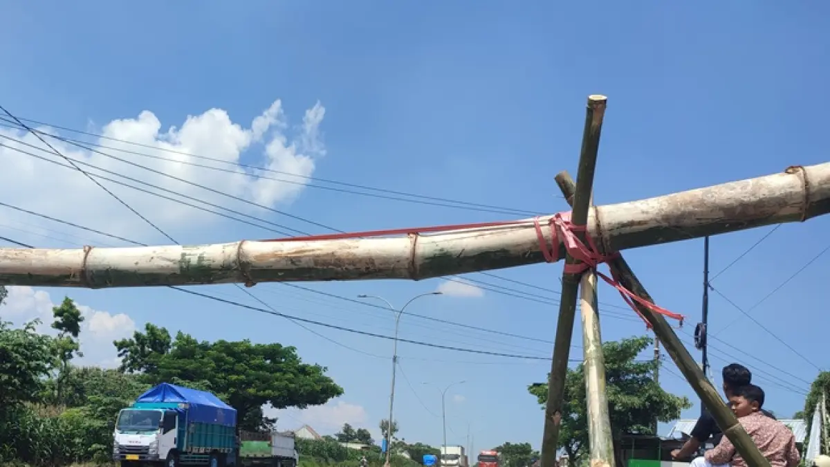 Kondisi salah satu lajur pada jalur ring road titik Desa Kowang, Kecamatan Semanding dipasangi plang bambu oleh warga setempat, imbas masih maraknya kendaraan yang menerobos lajur yang semestinya steril dari kendaraan berat, kemarin (1/4). (ANDREYAN/RADAR TUBAN)
