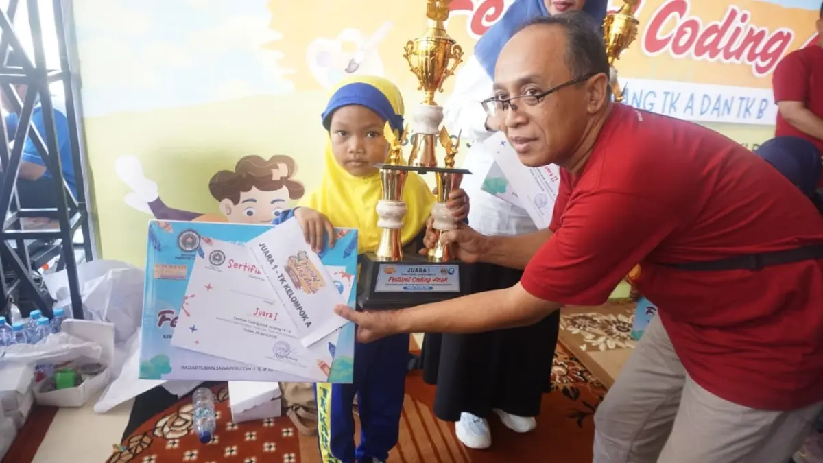 Elmeera menerima juara satu Festival Coding Jawa Pos Radar Tuban jenjang TK A oleh direktur Jawa Pos Radar Tuban, Sabtu (24/4) lalu. (ANDREYAN/RADAR TUBAN)