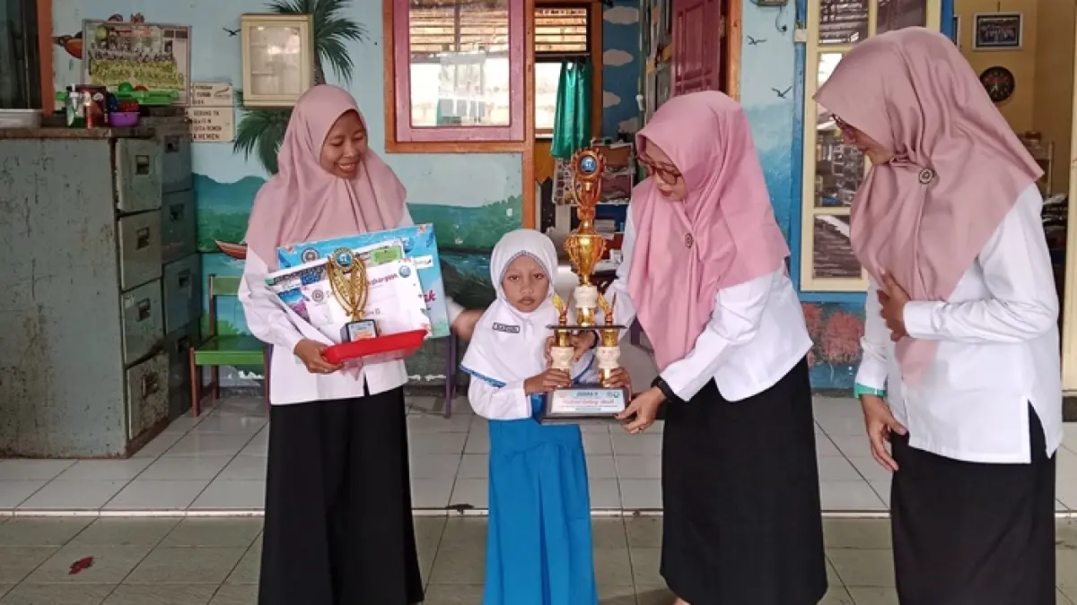 Nadhifa menerima piala dari guru pembimbing di sekolahnya karena saat pengumuman juara lomba Coding Jawa Pos Radar Tuban di Bravo Swalayan Tuban pada Sabtu (25/4) lalu sudah pulang. (RADAR TUBAN)