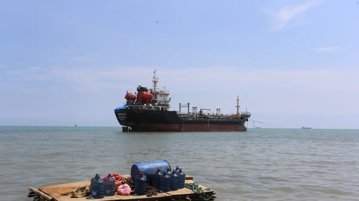 Sejumlah awak kapal MT Abigail W tampak menaiki perahu yang terbuat dari drum plastik setelah berbelanja bahan makanan di warga sekitar, Jumat (1/5). (M. MAHFUDZ MUNTAHA/RADAR TUBAN)