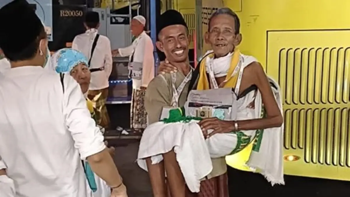 Jemaah kloter 29 Ngatmo Lekidin yang dibopong jemaah lain ketika hendak naik bus Shalawat nomor tujuh di Terminal Syib Amir. (DWI SETIYAWAN/RADAR TUBAN)