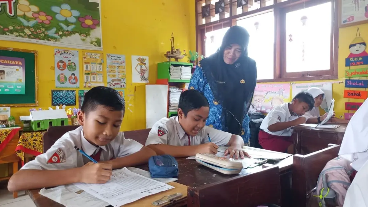 Pemimpin Redaksi Jawa Pos Radar Tuban Dwi Setiawan bersama dengan Kepala Sekolah SDN Latsari Kasmulik memantau pelaksanaan Lomba Literasi Numerasi di SDN Latsari pada tahun lalu. (SHAFA DINA HAYUNING MENTARI/ RADAR TUBAN)