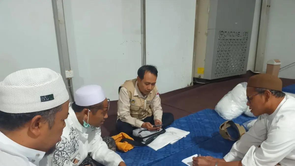 Ketua Kloter SUN 28 Misbahul Munir (tengah) berkoordinasi dengan petugas kloter dan perwakilan jemaah. (DWI SETIYAWAN/RADAR TUBAN)