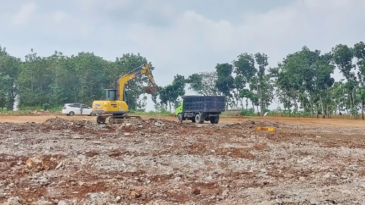 Ekskavator bekerja mengeruk semen reject yang menempel di lahan persil di Dusun Bribin, Desa Tuwiriwetan, Kecamatan Merakurak, kemarin (22/5). (M. MAHFUDZ MUNTAHA/RADAR TUBAN)