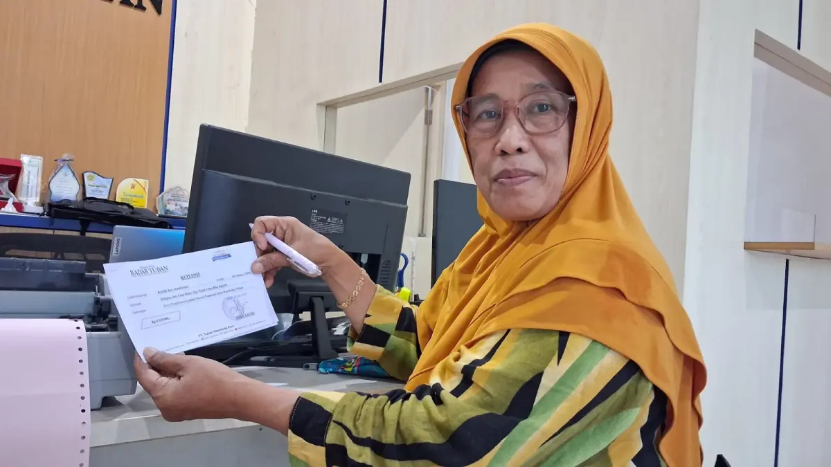 Bendahara K3S Kecamatan Kenduruan Indiati menyelesaikan administrasi Lomba Literasi dan Numerasi di kantor Jawa Pos Radar Tuban, kemarin (25/5). (HARDIYATI BUDI ANGGRAENI/RADAR TUBAN)