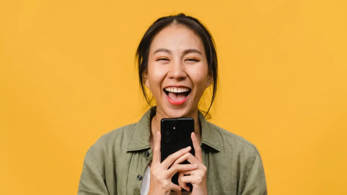 Ilustrasi orang tertawa saat scrolling ponsel. (magnific.com/tirachardz)