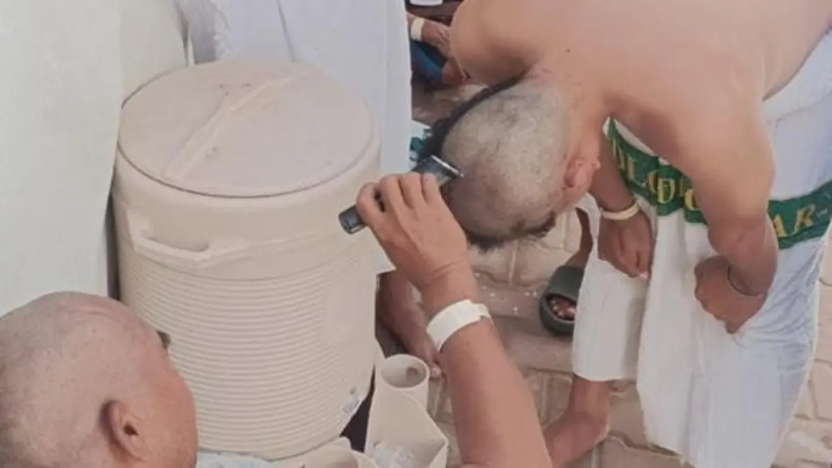 Jemaah haji Tuban bergantian mencukur rambut sesama jemaah dengan clipper setelah jumrah aqobah, salah satu rangkaian ibadah Armuzna. (DWI SETIYAWAN/RADAR TUBAN)