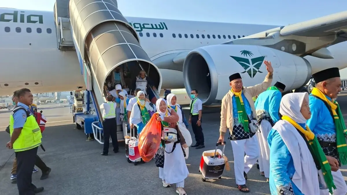 Jemaah haji Kloter SUB 29 turun dari pesawat Saudi Arabia Airline yang mendarat di Bandara Internasional Juanda Surabaya kemarin (8/6) pukul 07.07. (DWI SETIYAWAN/RADAR TUBAN)