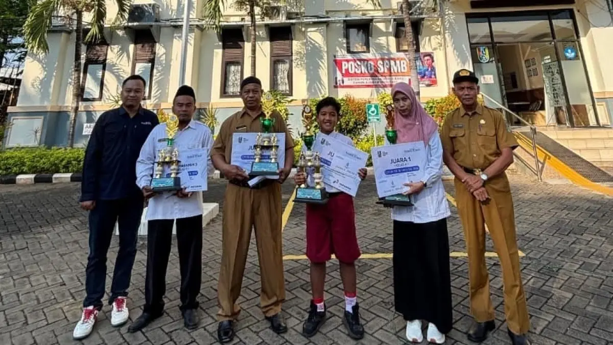 Kabid SD M. Nurdin bersama Manager Digital Jawa Pos Radar Tuban Yudha Satria Aditama memberikan piala dan piagam pada pemenang dan perwakilan pemenang jenjang kelas 4. (SINTA ARISKA/RADAR TUBAN)