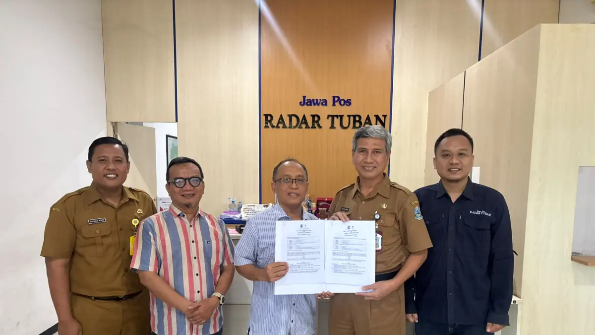 Kepala SMAN 1 Tuban Syaiful Annas bersama Direktur Jawa Pos Radar Tuban Tulus Widodo menunjukkan MoU untuk memperkuat kerja sama publikasi, edukasi siswa, dan program sekolah anti asap rokok. (M. AZLAN SYAH/RADAR TUBAN)