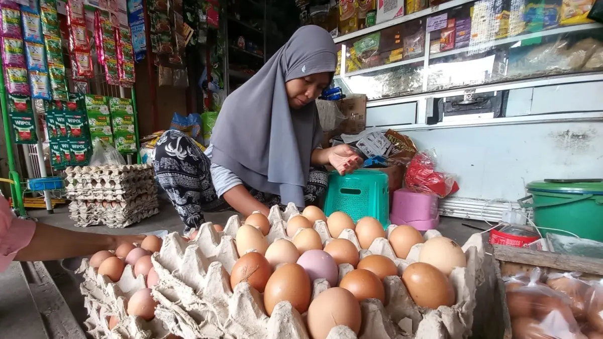 Salah seorang pedagang di Pasar Pramuka tengah menata pasokan telur ayam di lapaknya, kemarin (5/6). (SHAFA DINA HAYUNING MENTARI/ RADAR TUBAN)