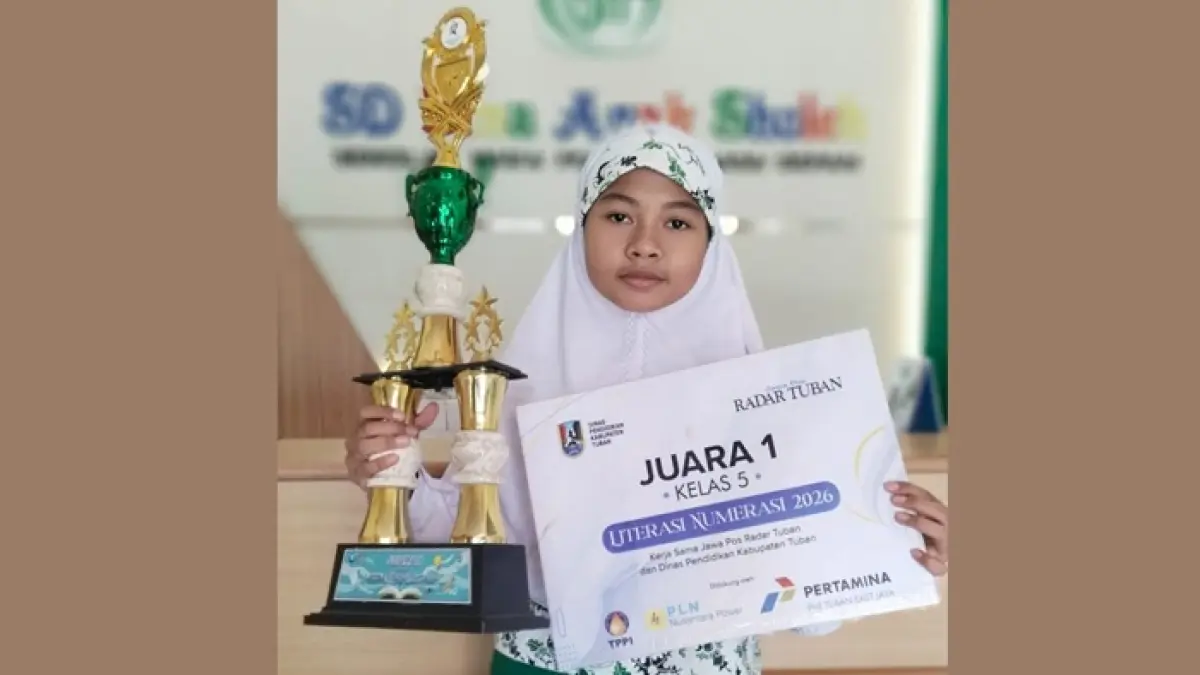 Azalea tampak bahagia ketika menunjukkan piala dan piagam kejuaraannya dalam ajang Lomba Literasi Numerasi 2026. (RADAR TUBAN)