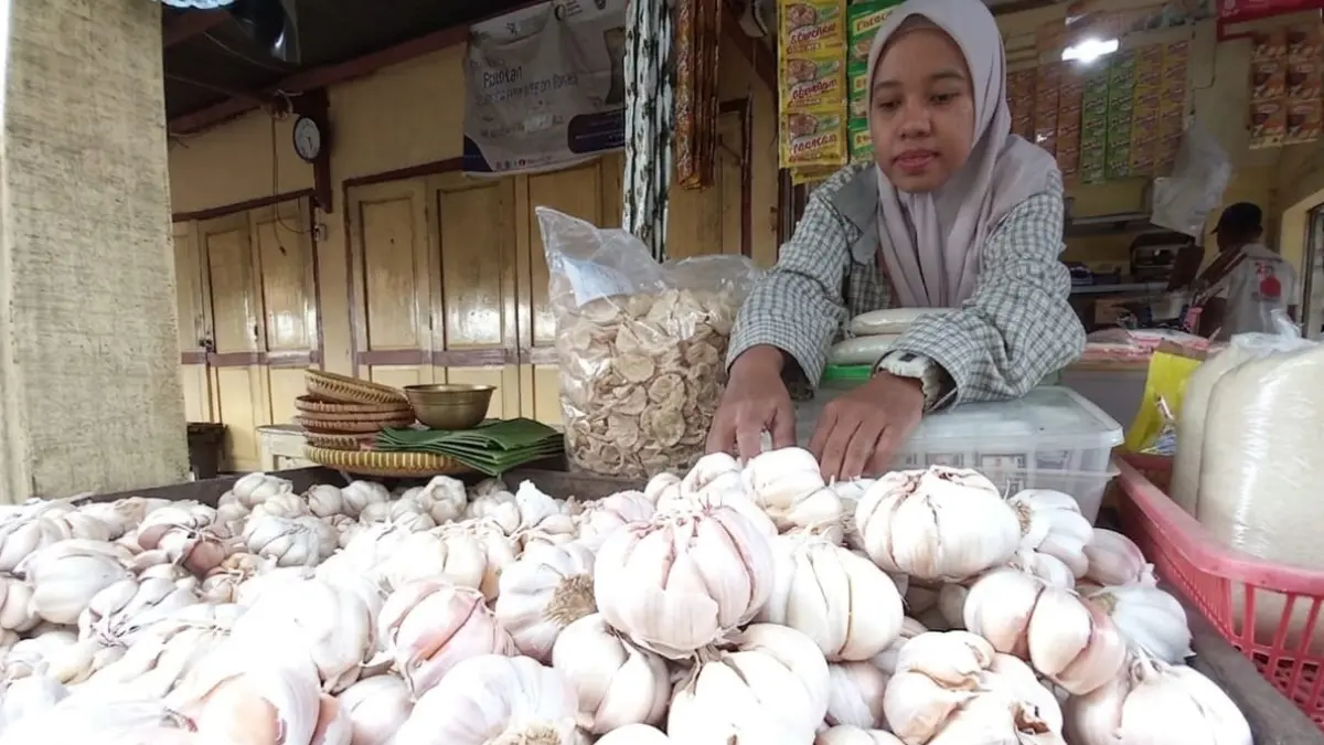 Pedagang di Pasar Baru Tuban menata stok bawang putih dagangannya, kemarin (17/6). (SHAFA DINA HAYUNING MENTARI/ TUBAN)