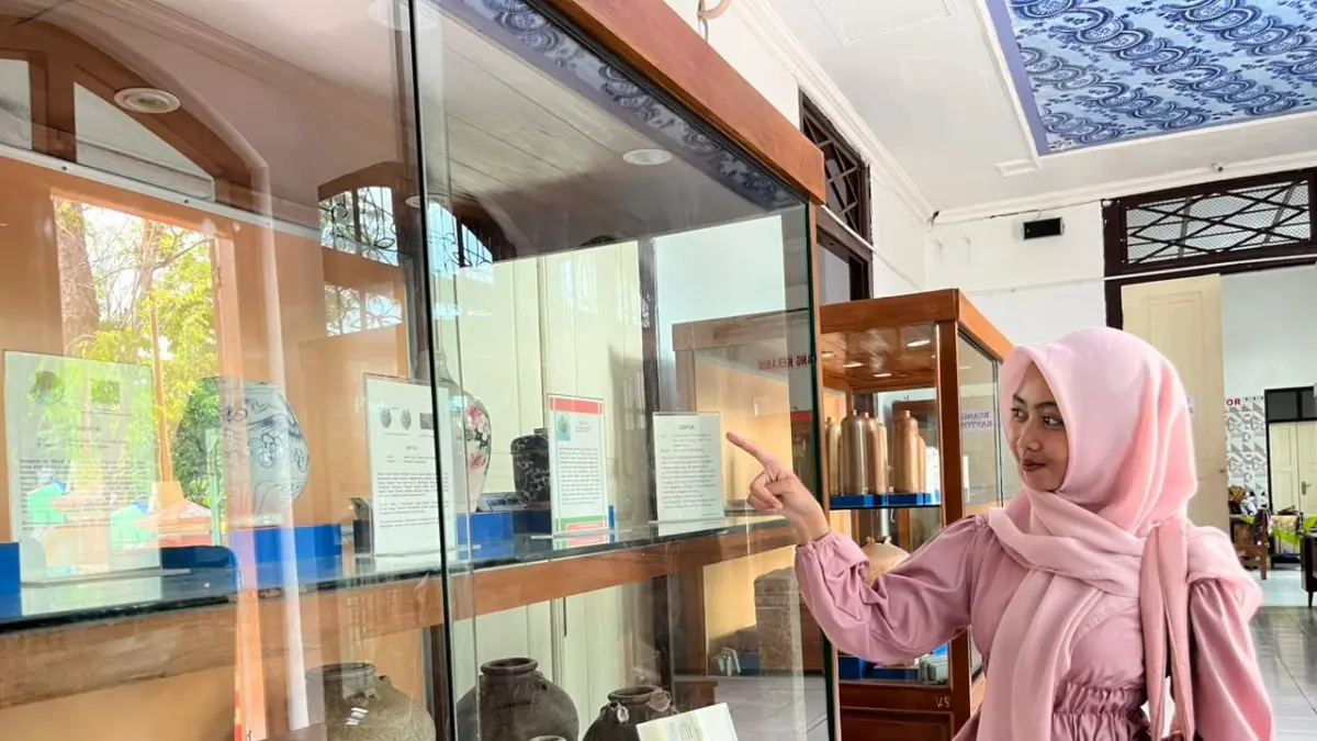 Salah seorang pengunjung mengamati koleksi keramik Tiongkok dalam etalase di Museum Kambang Putih Tuban. (SHAFA DINA HAYUNING MENTARI/ RADAR TUBAN)