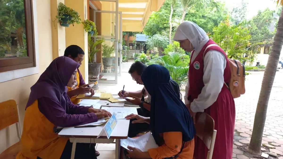 Panitia SPMB SMP negeri dan orang tua siswa saat mengecek berkas daftar ulang. (SHAFA DINA HAYUNING MENTARI/RADAR TUBAN)