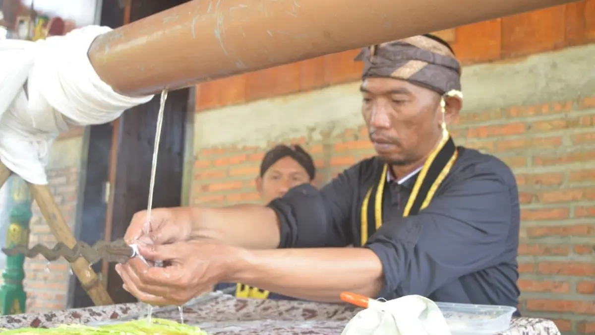 Seorang pemangku budaya dari Paguyuban Tosan Aji Megalamat Tuban tampak khidmat memandikan keris dalam kegiatan Jamasan Pusaka Massal, Minggu (5/7). (Paguyuban Tosan Aji Megalamat Tuban untuk Radar Tuban)