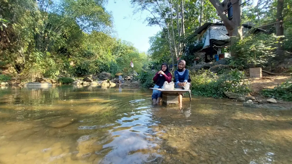 Pengunjung Cafe di Banyulangse memilih duduk di aliran sungai karena lebih sejuk, bisa sekalian main air. (M. Mahfudz Muntaha/Radar Tuban)
