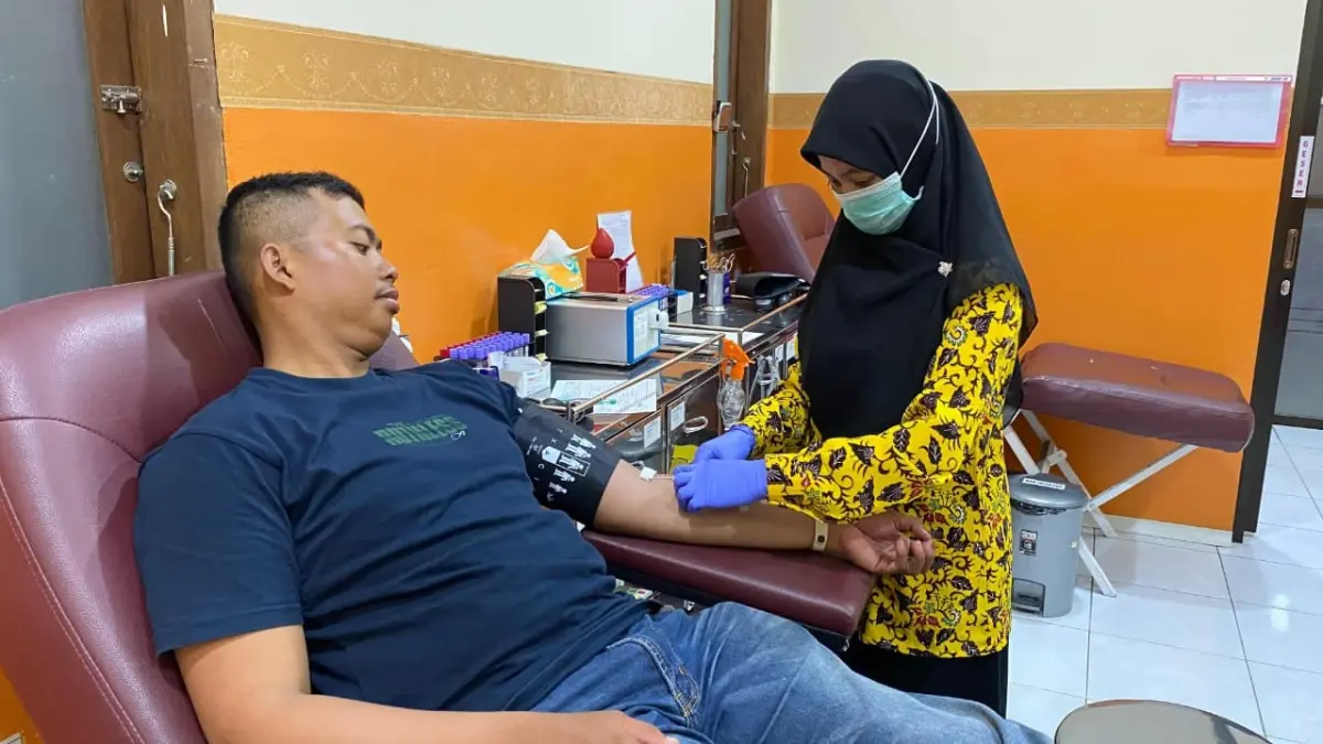 Salah seorang petugas UDD PMI Tuban melakukan pengambilan darah dari seorang pendonor. (RADAR TUBAN)